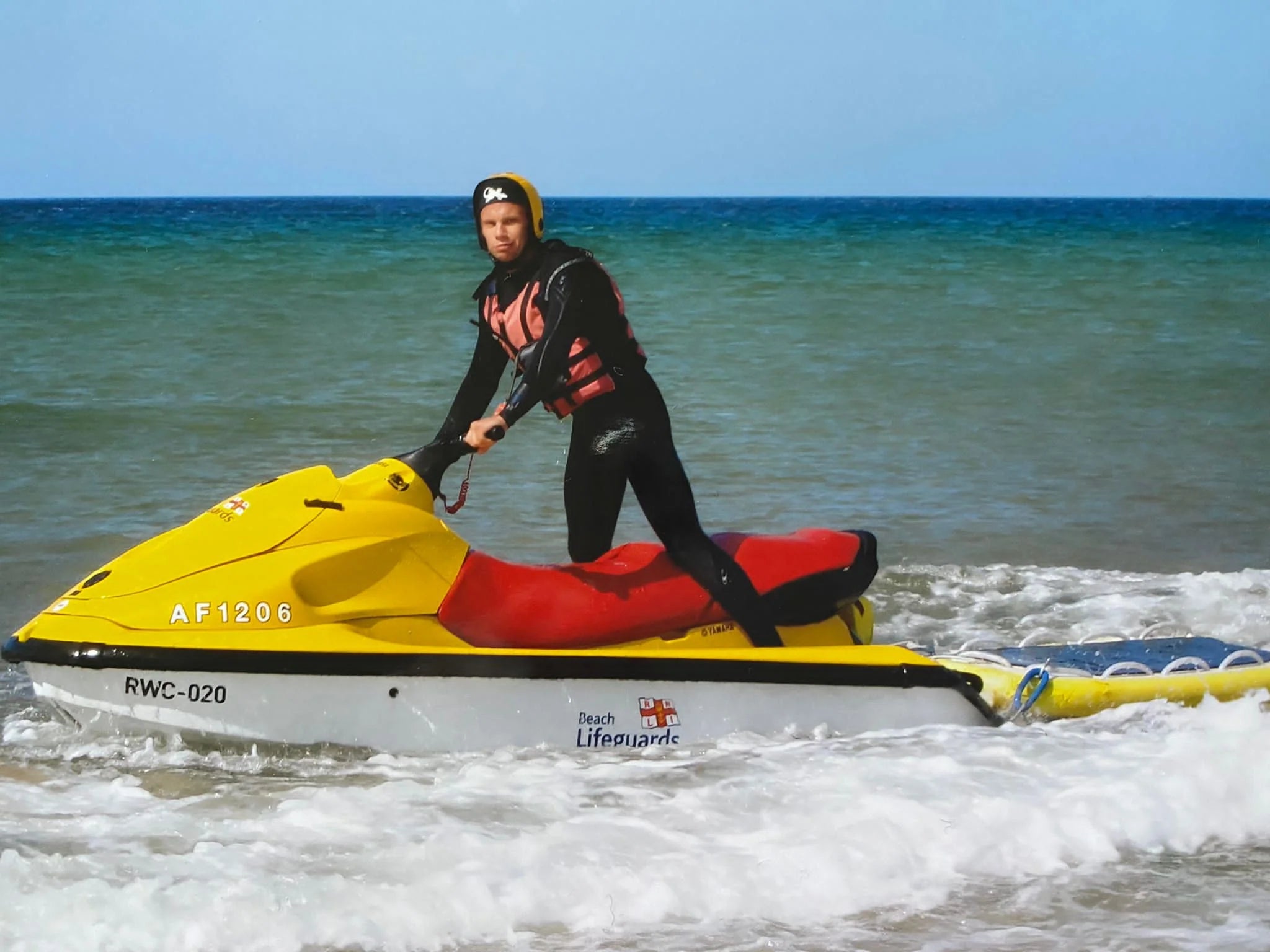 Ben on a beach that's covered in plastic and other rubbish