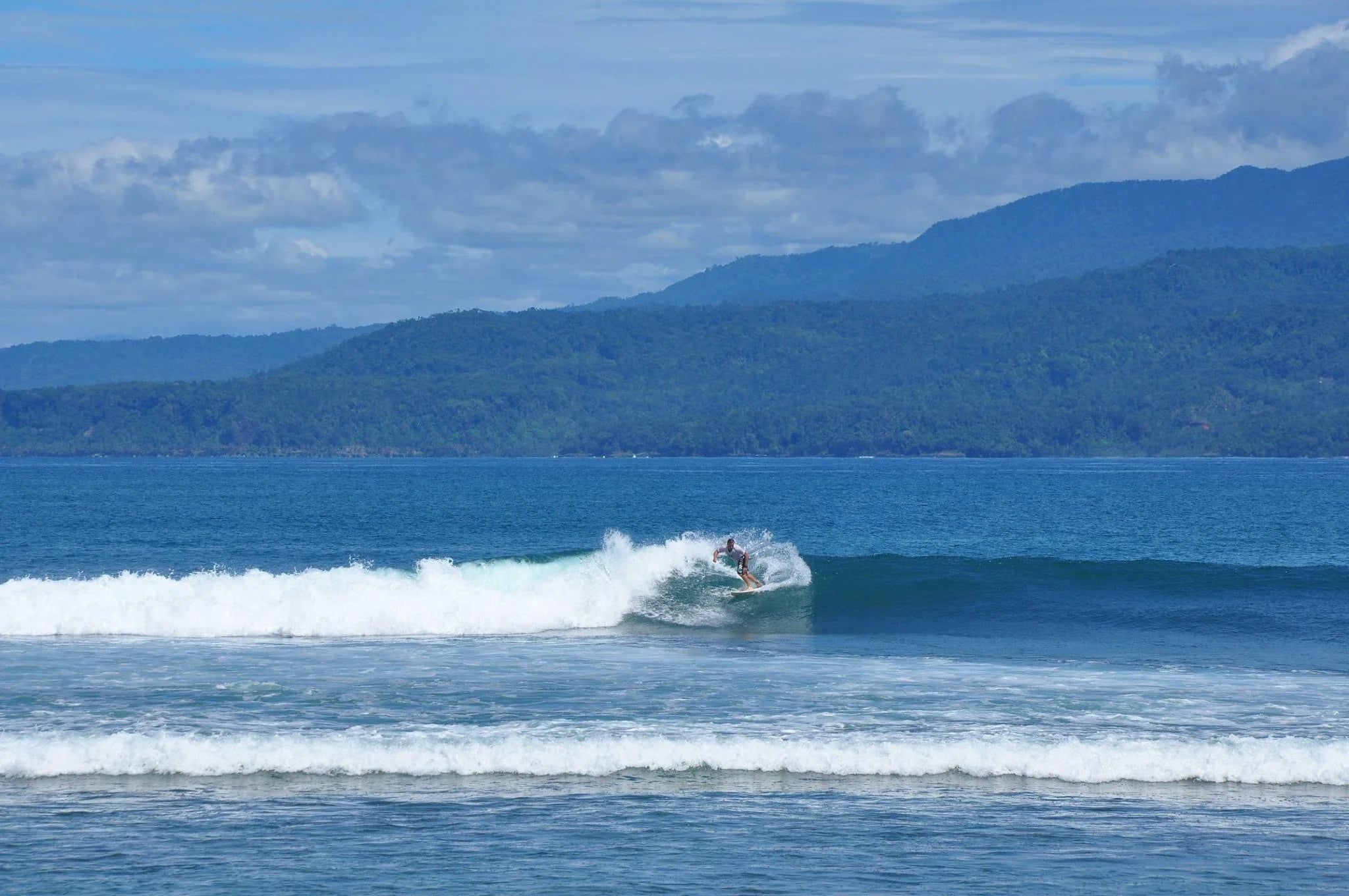 Ben on a surf board, in the sea looking into the horizon